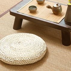 a coffee table with some tea pots on it and a small stool next to it