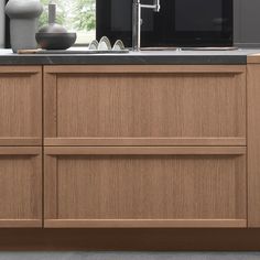 an image of a kitchen setting with wood cabinets and black counter tops in the background