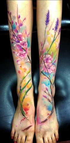 two people with tattoos on their legs, one has flowers and the other has birds