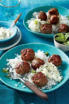 meatballs and mashed potatoes are served on blue plates with silverware next to them