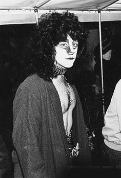 an old black and white photo of a woman with makeup on her face standing under a tent