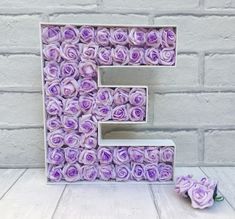 the letter e is made out of purple roses