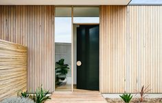 an entrance to a modern home with wood siding