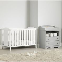 a baby crib next to a dresser in a room with white walls and carpet