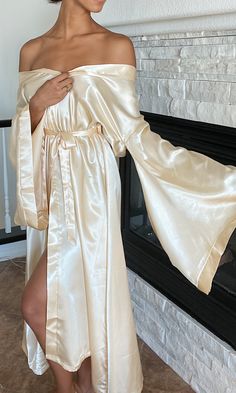 This soft gold silky floor-length robe is the perfect staple piece to own. A smooth belt drapes around to tie at the front, wrapping the fabric up softly. With a crisp neckline and wide sleeves, this kimono robe can be worn to lounge around comfortably, as a bridal robe, or to add a luxurious touch to relax in Bridal Robes, Wide Sleeves, Staple Pieces, Floor Length, Off Shoulder Dress, Strapless Dress, Fabric