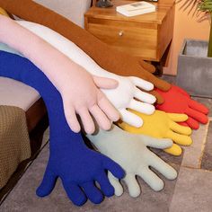 five pairs of gloves are stacked on top of each other in front of a bed