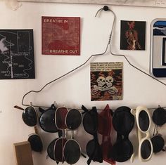 there are many pairs of sunglasses hanging on the wall next to pictures and magnets