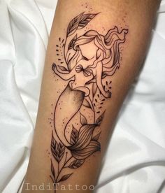 a woman's leg with a mermaid tattoo on it