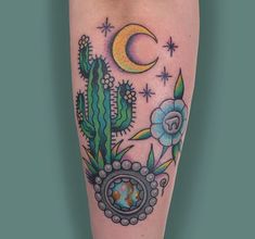 a cactus and moon tattoo on the left leg, with stars in the sky above it