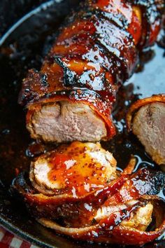 some meat is being cooked in a skillet with sauce on the top and sides