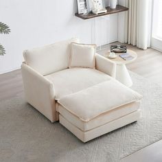 a white chair sitting on top of a rug in a living room next to a window