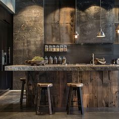 a kitchen with two wooden stools next to a counter top and an island in the middle