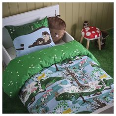 a child's bed with green and blue comforters, mushrooms, and trees