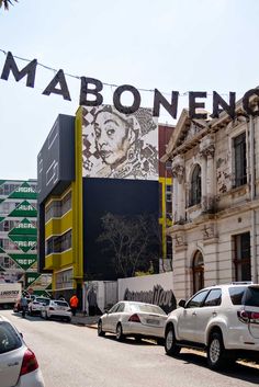 cars are parked in front of a building with a sign that says maboneeng