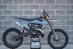 a dirt bike parked next to a brick wall