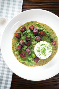 a white bowl filled with soup on top of a wooden table