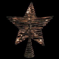 a lighted christmas tree star hanging from the ceiling in front of a black background with white lights