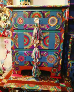 an ornate dresser with colorful designs and tassels