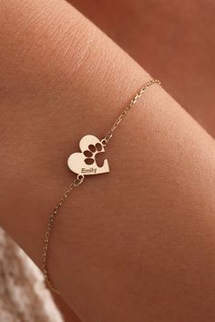 a woman's arm with a gold bracelet that has two hearts and the word family on it