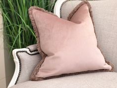 a pink pillow sitting on top of a white couch