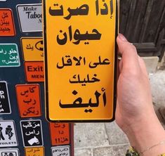 a person holding up a yellow sign with arabic writing