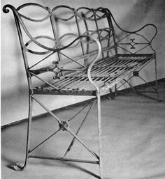 an iron bed frame sitting on top of a white sheet covered floor next to a wall