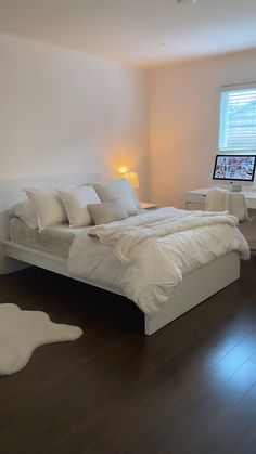 a large white bed sitting in a bedroom next to a window