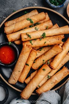 some food is on a black plate with sauces and spoons next to it