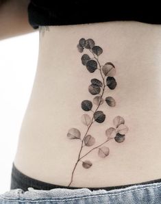 a woman's stomach with a small flower tattoo on her side ribcage