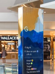 a glass sign in the middle of a shopping mall