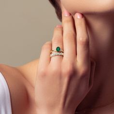 a woman's hand with a ring on her finger and an emerald in the middle