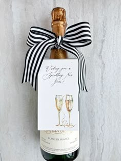 a bottle of wine with a ribbon around it and a card attached to the top