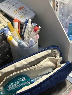 the inside of a bag with pens, pencils and other office supplies in it