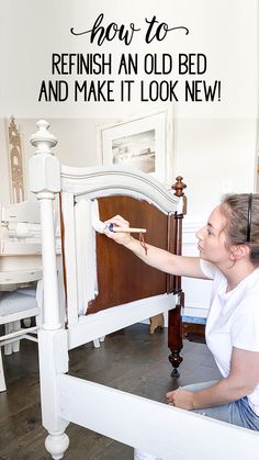 a woman is painting an old bed frame with white paint and black lettering on it