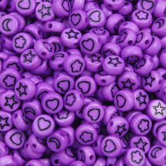 purple plastic beads with black hearts and stars in the shape of heart's on them