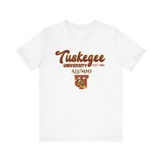 Tuskegee University Alumni T-Shirt The unisex heavy cotton tee is the basic staple of any wardrobe. It is the foundation upon which casual fashion grows. All it needs is a personalized design to elevate things to profitability. The specially spun fibers provide a smooth surface for premium printing vividity and sharpness. No side seams mean there are no itchy interruptions under the arms. The shoulders have tape for improved durability. .: 100% cotton (fiber content may vary for different colors) .: Medium fabric (5.3 oz/yd² (180 g/m .: Classic fit .: Tear-away label .: Runs true to size Casual Short Sleeve T-shirt With University Logo, White Short Sleeve Top With University Logo, Collegiate White T-shirt With University Logo, University Logo Short Sleeve Fan Apparel Top, University Logo Graphic Tee With Crew Neck, White University Logo T-shirt With Crew Neck, University Logo Cotton Graphic Tee, University Logo Graphic Cotton T-shirt, University Logo Graphic Tee In Cotton