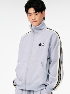 This casual track jacket features daisy motif embroidery on chest and stripe tape along outside of sleeves. It's cut from cozy and warm napping back fabric.- High-neck- Zip-up fastening- Graphic embroidery on chest- Front pouch pockets- Stripe tape at sleeves- Ribbed cuffs and hem- Oversized fit- Unisex wear Spring Track Jacket With Contrast Stripes And Long Sleeves, Spring Track Jacket With Contrast Stripes, Spring Streetwear Track Jacket With Contrast Stripes, Winter Cotton Outerwear With Contrast Stripes, Winter Cotton Track Jacket With Ribbed Collar, Casual Track Jacket With Contrast Stripes, Long Sleeve Outerwear With Three Stripes For Spring, Cotton Outerwear With Three Stripes For Fall, Casual Spring Track Jacket With Contrast Stripes