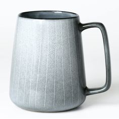 a gray coffee mug sitting on top of a white table