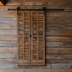 an old wooden window with shutters on the side of a building that is made out of wood planks