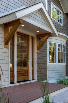 the front door of a house with two windows and wooden steps leading up to it