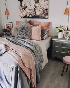 a bed room with a neatly made bed next to a painting on the wall and two nightstands