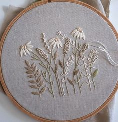 a close up of a embroidery on a piece of cloth with flowers in the middle