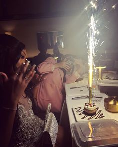 two women sitting at a table with sparklers in their hands