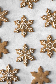 gingerbread cookies with royal icing are arranged in the shape of snowflakes