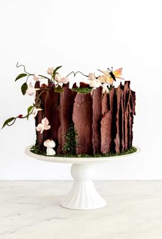 a chocolate cake with flowers and moss on top