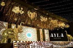 lights and decorations are hanging from the ceiling in an indoor area with elephants on display