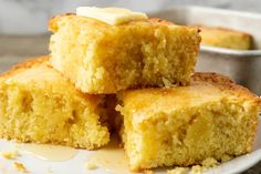 three pieces of cake sitting on top of a white plate next to a small bowl