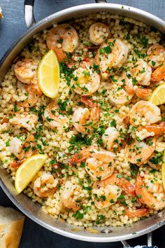 shrimp and rice with lemon wedges in a skillet