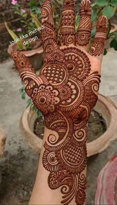 the hand is decorated with henna on it and has an intricate design in the middle