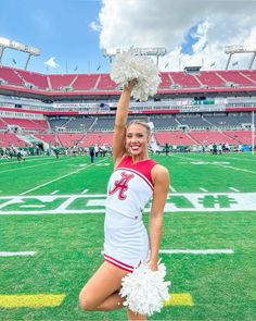 a cheerleader is posing on the field at a football game